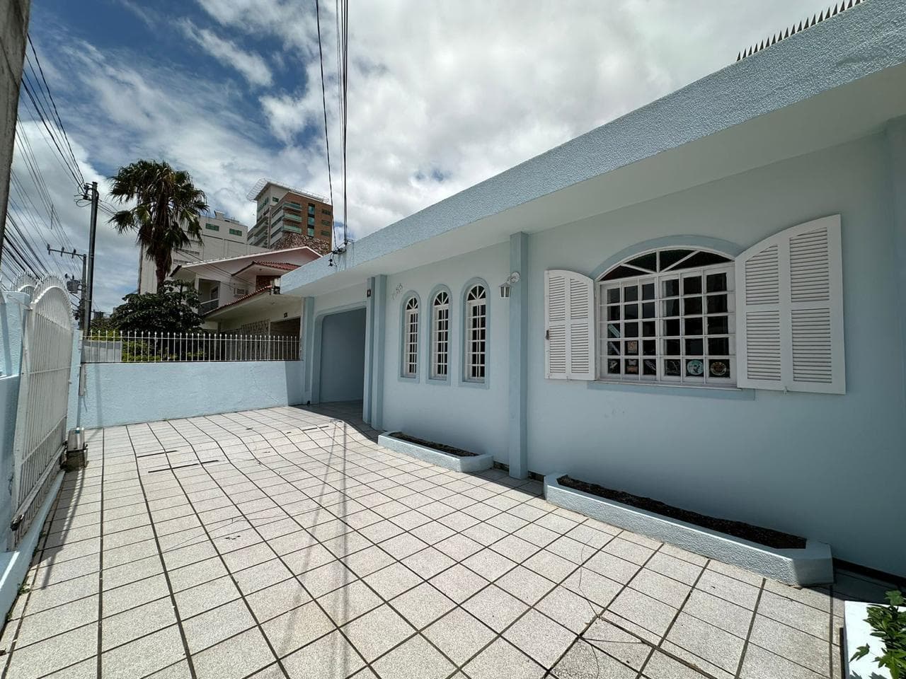 Frente da casa com pátio e janelas em arco